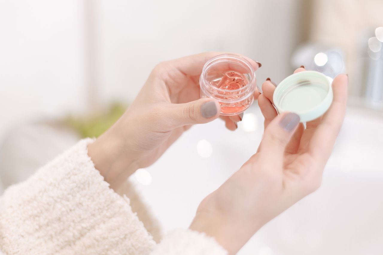 The Art of Drawing Readers In: Your attractive post title goes here Close-up of a woman applying moisturizer from a container, showcasing soft hands and gentle care.